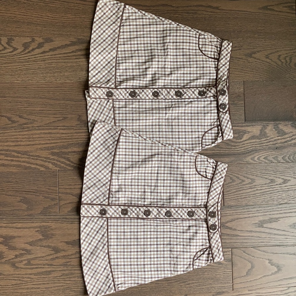 Checkered brown white skirts with brown buttons.